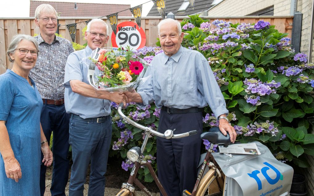 Rayonhoofd Wim van der Sluys overhandigde vrijdag 19 juli bloemen aan RD-bezorger Arris Methorst, die negentig jaar werd. Linksachter Wim Achterstraat. beeld Herman Stöver