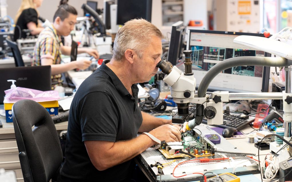 Jan Post van Reparatiewinkel Ede aan het werk achter zijn bureau. beeld Niek Stam