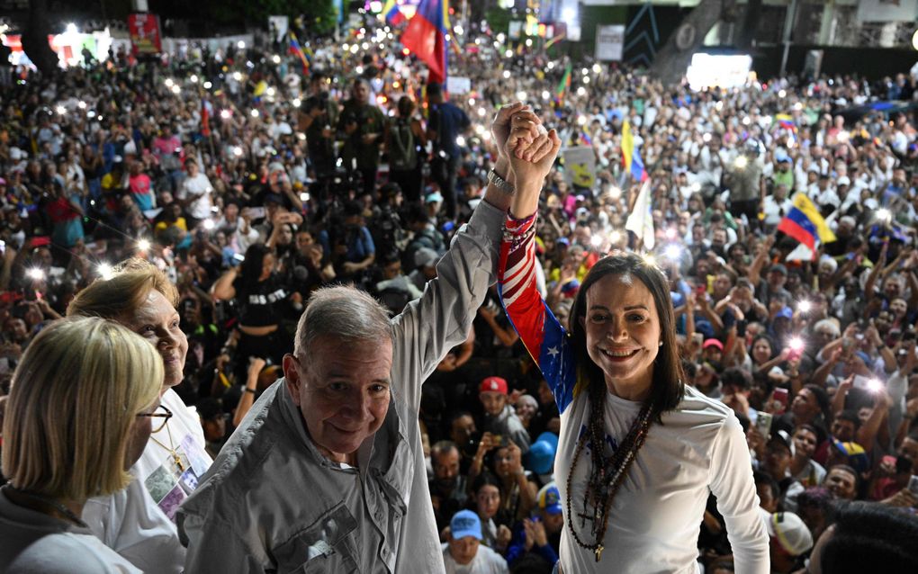 De Venezolaanse oppositiekandidaat Edmundo Gonzalez Urrutia en oppositieleider Maria Corina Machado (r.) begroeten hun aanhangers tijdens een campagnebijeenkomst. beeld AFP, Federico Parra