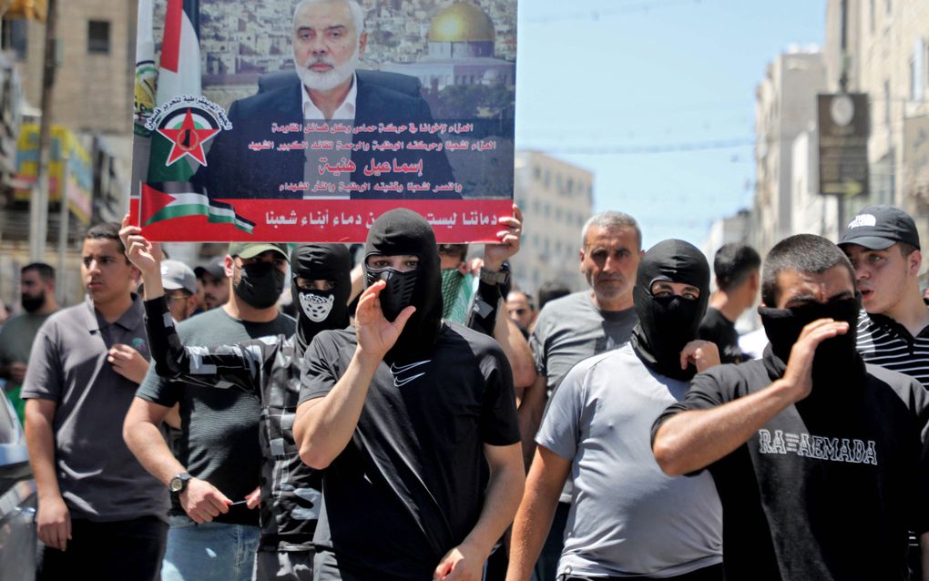 Palestijnen in de Westbank lopen met afbeeldingen van Haniyeh in een demonstratie tegen de Israëlische actie waarbij de topman van Hamas om het leven kwam. beeld AFP