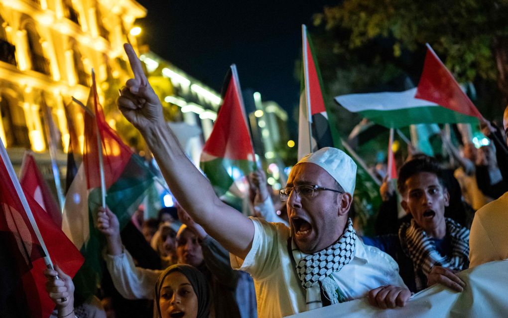 Betogers zwaaien woensdagavond met Palestijnse vlaggen in de Turkse stad Istanbul. De demonstranten protesteren tegen het ombrengen van de politieke leider van Hamas, Ismail Haniyeh. beeld AFP, Kemal Aslan