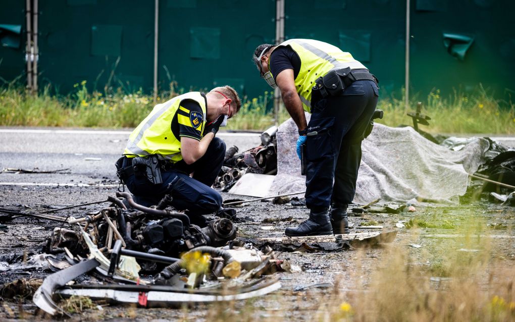 Politie doet onderzoek bij de brokstukken op de A58 van een neergestort vliegtuig. beeld ANP, Jeffrey Groeneweg