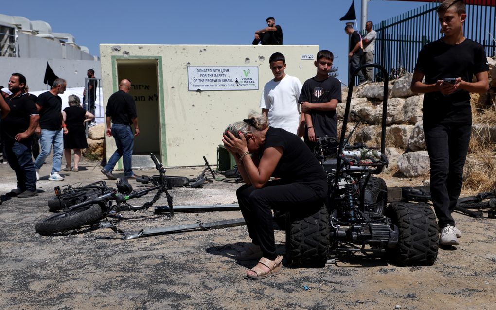 Een vrouw in Majdal Shams rouwt maandag op de plek waar een familielid zaterdag om het leven is gekomen. beeld EPA, Atef Safadi