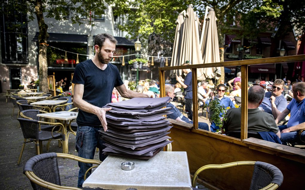 Een horecaondernemer sluit zijn terras. Vooral voor kleine horecabedrijven is het een uitdaging om na slechte beoordelingen nog genoeg klanten te trekken. beeld ANP, Ramon van Flymen