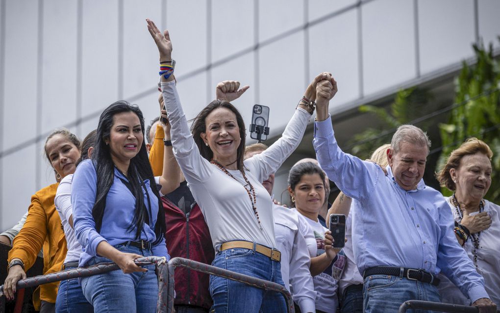 De Venezolaanse oppositieleider Maria Corina Machado (links) houdt de arm van oppositiekandidaat Edmundo Gónzalez (rechts) omhoog in Caracas, de hoofdstad van Venezuela. beeld EPA, Henry Chirinos