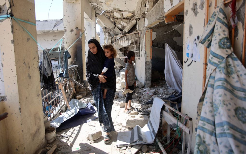 Een Palestijnse vrouw met haar dochtertje in een verwoeste school in Gaza. beeld AFP, Omar AL-QATTAA 