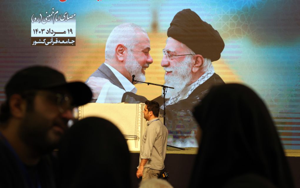 Een billboard in Teheran met daarop de afbeeldingen van de omgebrachte Hamasleider Ismail Haniyeh (l.) en de geestelijk leider van Iran, ayatollah Ali Khamenei. beeld EPA