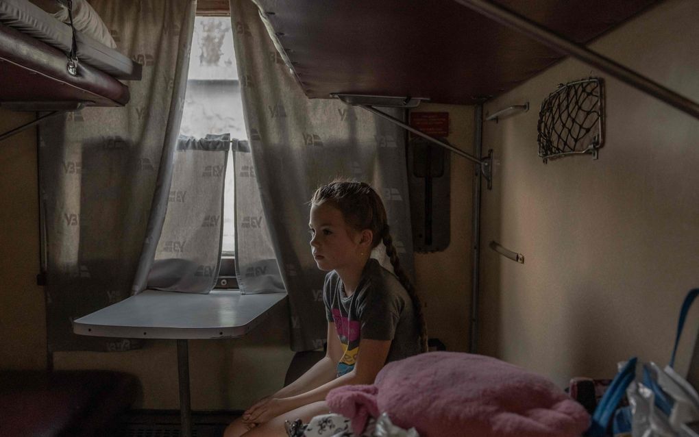 Alona (8) wordt, samen met haar moeder en broer, geëvacueerd per trein uit grensplaats Novogrodivka in Donetsk. beeld AFP, Roman PILIPEY