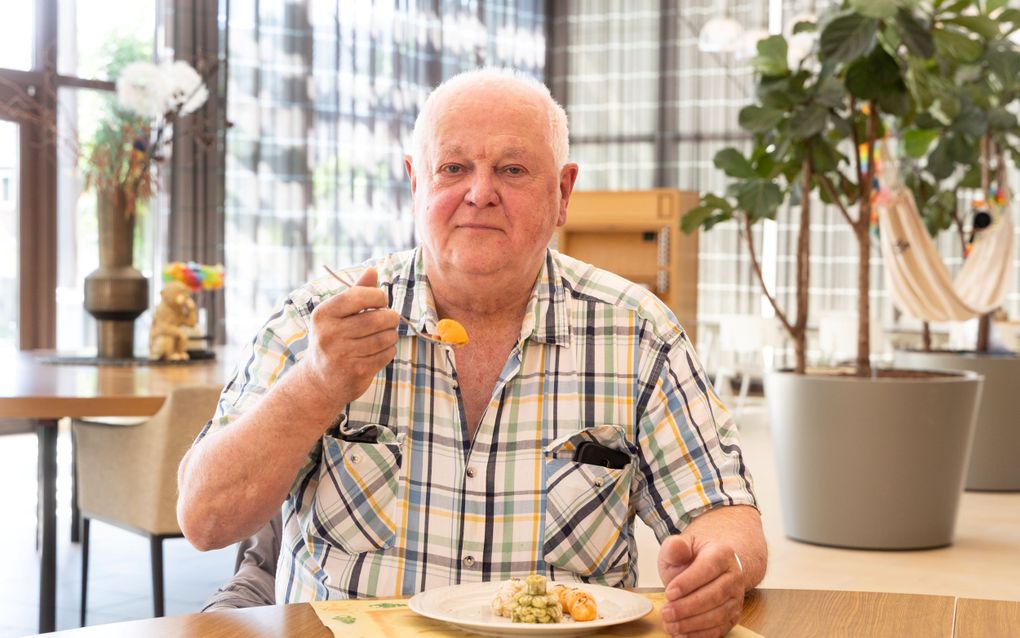 Jan neemt een hap groente uit de 3D-printer. De zoete aardappel smaakt prima, vindt de bewoner van woonzorgcentrum IJsselheem. beeld RD, Anton Dommerholt