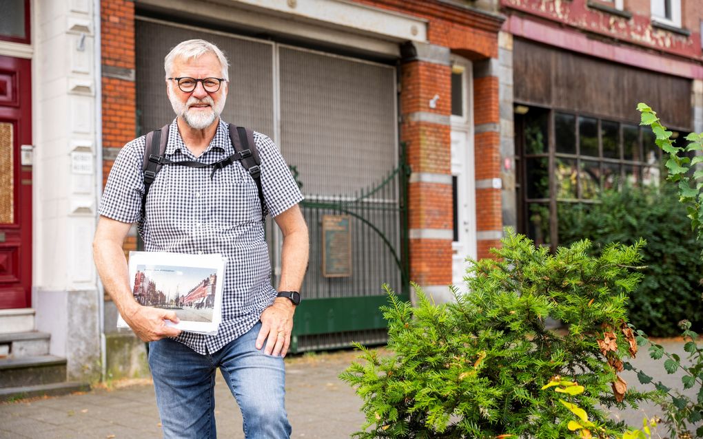 Rob Snijders, gids Joods erfgoed in Rotterdam, poseert op de plek waar vroeger het Joodse ziekenhuis Megon Hatsedek stond. Nu rest alleen nog het groene toegangshek. beeld Cees van der Wal 