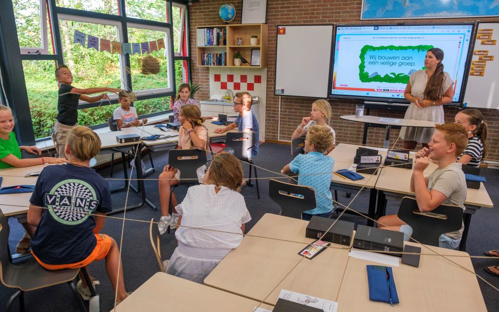 De scholen in Zuid-Nederland zijn maandagmorgen weer begonnen. Groep 8 van de Petrus Immensschool in Middelburg –de school bestaat volgende maand vijftig jaar– speelde na de dagopening onder leiding van juf Nieuwenhuyzen een spel met wol om zo te bouwen aan een ”veilige groep”. beeld Dirk-Jan Gjeltema