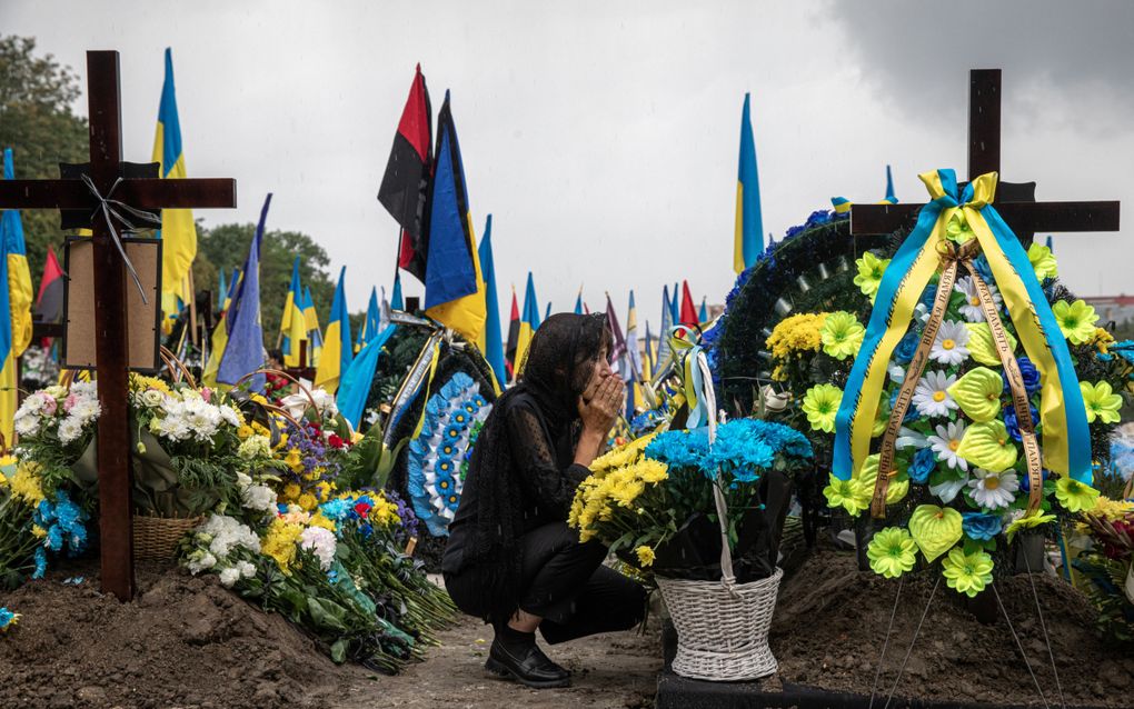 Een moeder huilt bij het graf van haar zoon, een Oekraïense soldaat die gedood is aan het front. beeld Kostyantyn Chemichkin