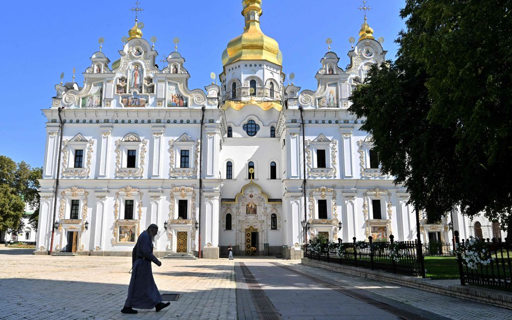 Een monnik loopt langs een kathedraal in Kyiv. beeld AFP, Sergei Supinsky