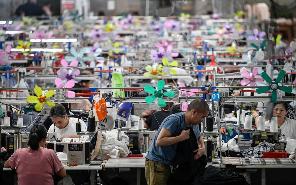 Arbeiders maken kleding in de fabricagehal van het Chinese modemerk Shein in Guangzhou. beeld AFP, Jade Gao