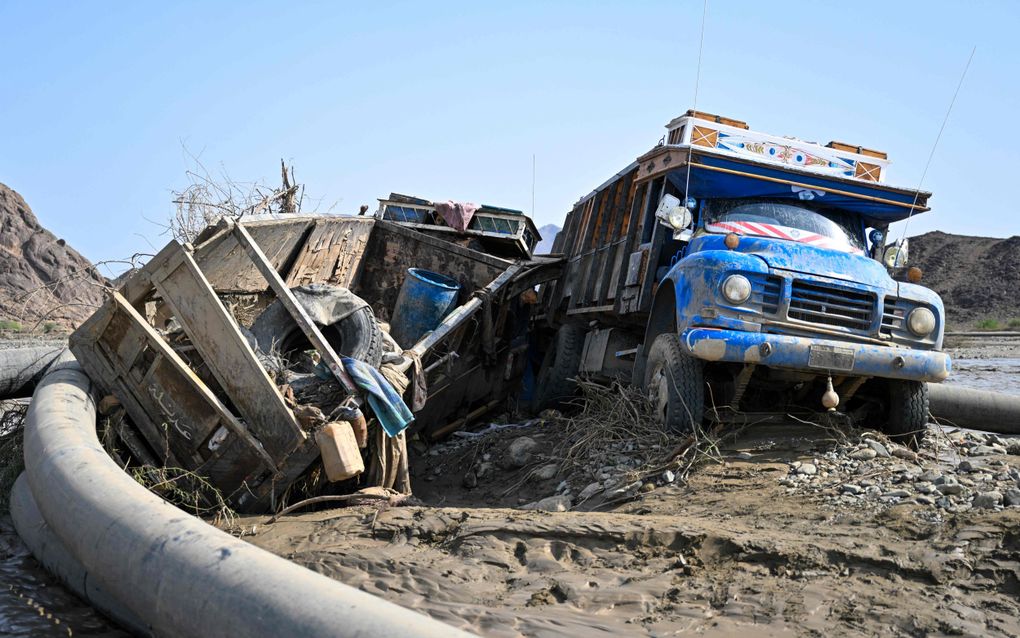 Beschadigde vrachtwagens, bedolven onder de modder na een damdoorbraak in Sudan. beeld AFP