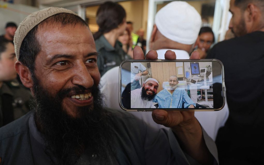 De broer van de bevrijde gijzelaar laat en foto zien van de ontmoeting die zij hadden. beeld AFP, Menahem Kahana 