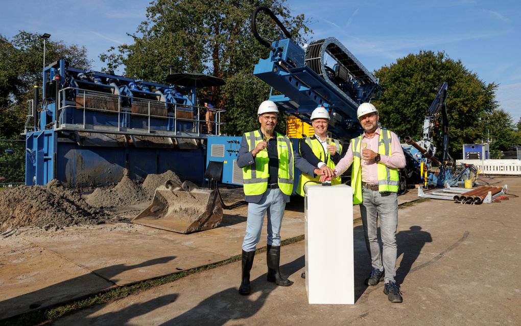 Diederik Engelsman van TenneT, wethouder Engbert Stroobosscher en Michael Melssen van Platform Hoogspanning (v.l.n.r.) drukken symbolisch op een knop om de start van de boringen voor het ondergronds aanleggen van hoogspanningskabels in Veenendaal te markeren. beeld gemeente Veenendaal