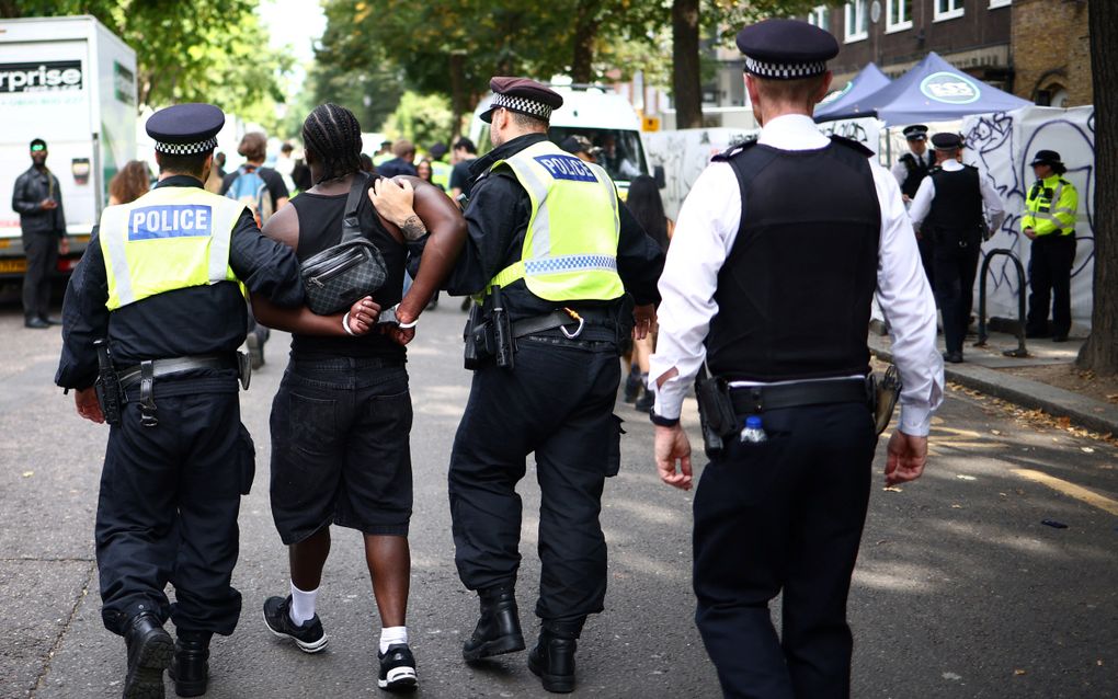 Een man wordt op maandag 26 augustus afgevoerd van het carnavalsfeest in de Londense wijk Notting Hill. beeld AFP, Henry Nicholls