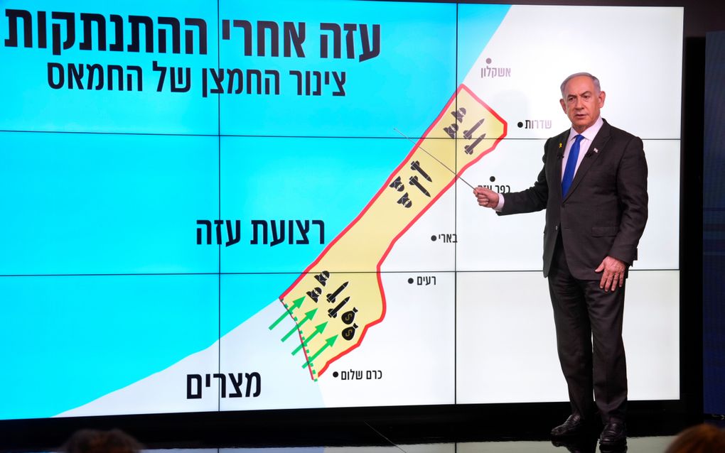 De Israëlische premier Benjamin Netanyahu legt verslaggevers maandag uit hoe Hamas in de Gazastrook wapens importeert. Bij de vier groene pijlen onderaan de kaart ligt de Philadelphicorridor. beeld EPA, Ohad Zwigenberg