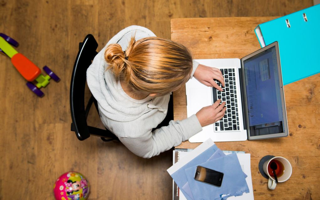 Menig werknemer klapt buiten werktijd thuis toch even de laptop open na een telefoontje van de baas. Wat vakbond FNV betreft mogen werknemers telefoontjes of mailtjes van de baas na werktijd voortaan negeren. beeld ANP, Roos Koole