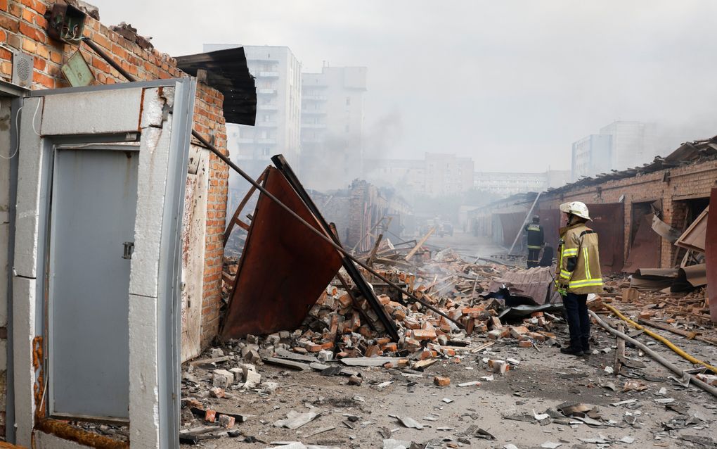 Oekraïense hulpdiensten bij een verwoest gebouw in Charkiv op maandag. beeld EPA, Sergey Kozlov 