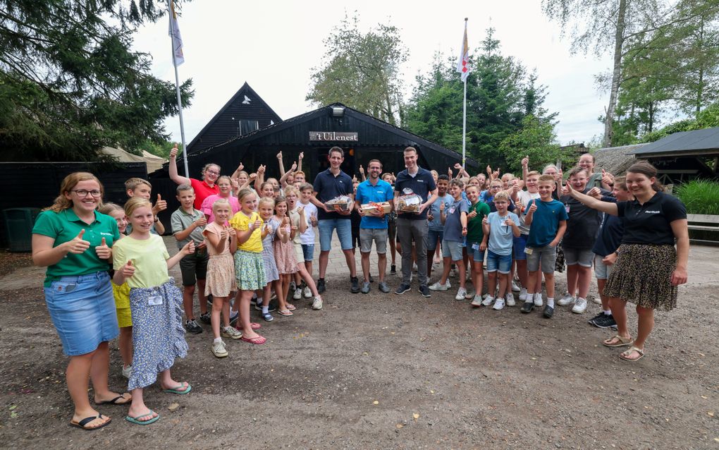 Geerthilde Wisse overhandigt haar drie medestafleden een notenpakket tijdens de Koersvakantie in Geldrop. beeld Fotopersburo Bert Jansen