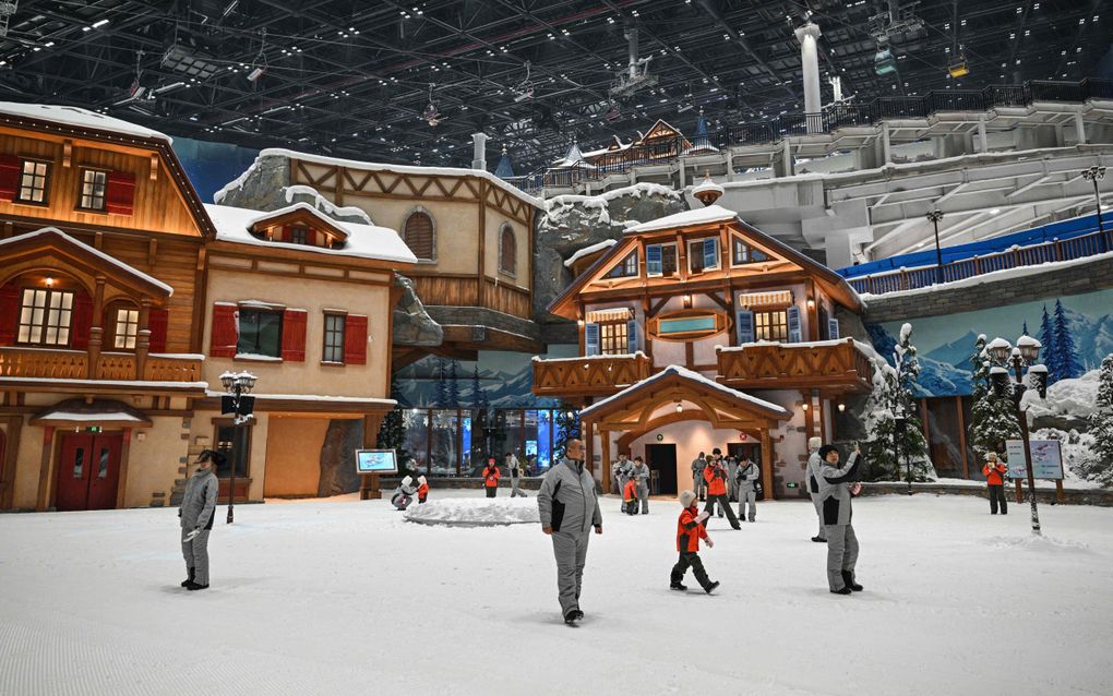 Mensen wandelen door het Shanghai Snow Indoor Skiing Theme Resort. Het grootste skiresort ter wereld werd deze week geopend in China. beeld AFP, Hector Retamal  