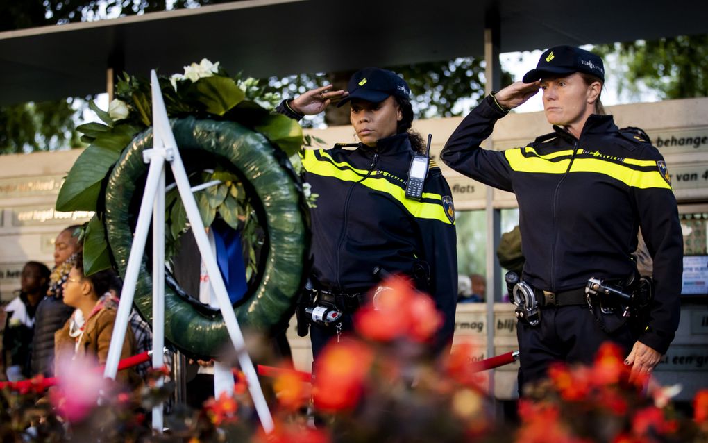 Agenten leggen een krans tijdens een herdenking van de Bijlmervliegramp die plaatsvond in 1992, toen een vrachttoestel van de Israëlische vliegmaatschappij El Al neerstortte op de flats Groeneveen en Klein-Kruitberg in de Amsterdamse Bijlmer. beeld ANP, Koen van Weel