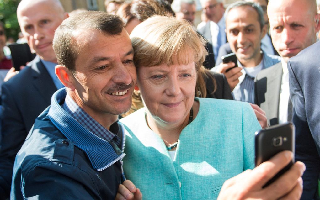 Een asielzoeker maakt in 2015 een selfie met de toenmalige bondskanselier Angela Merkel. beeld AFP, Bernd von Jutrczenka