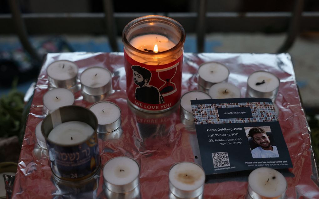 Pictures of killed Israeli hostage Hersh Goldberg-Polin are placed among candles during a  vigil accompanied by prayers held for his memory in Jerusalem on September 1, 2024, after Israel announced its troops had found six dead hostages in a Gaza tunnel, including Polin. The six were among 251 hostages seized during Hamas's October 7 attack that triggered the ongoing war between Israel and Hamas, 97 of whom remain captive in Gaza including 33 the army says are dead. Scores were released during a negotiated one-week truce in November. (Photo by AHMAD GHARABLI / AFP)