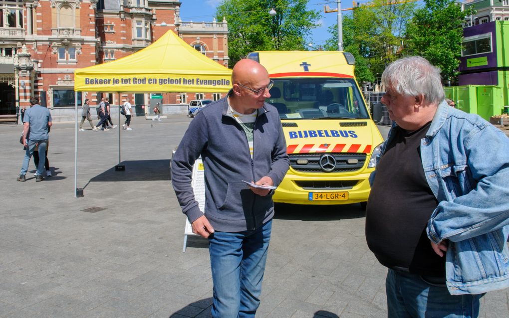 Straatevangelist Jan-Dirk Liefting in gesprek met voorbijgangers op het Amsterdamse Leidseplein. Stichting Evangelisatie Sjofar ontwikkelde een nieuwe training om mensen toe te rusten voor het evangelisatiewerk. beeld Ronald Bakker