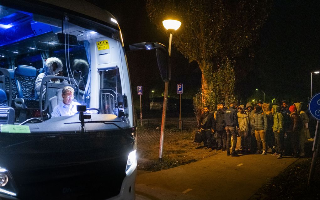 Een bus arriveert maandagavond bij het asielzoekerscentrum Ter Apel om asielzoekers naar een noodopvang in Stadskanaal te brengen. beeld ANP, JILMER POSTMA