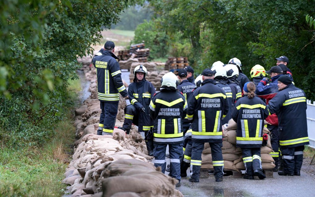 Brandweerlieden zijn druk in de weer met zandzakken in Hadersdorf am Kamp, Oostenrijk. beeld AFP, Roland Schlager