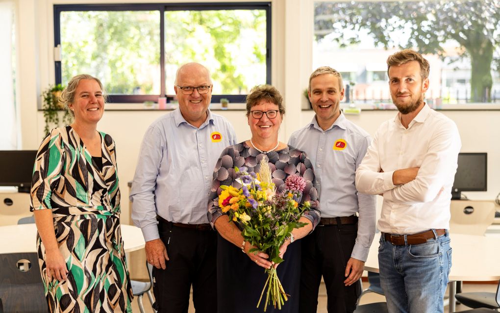 Jannie van de Worp-Wielink krijgt een bloemetje van haar collega's van het team Zorg-en-Welzijn van de Jacobus Fruytier Scholengemeenschap in Apeldoorn. V.l.n.r.: Mariska Koppejan, Gerrit Top, Jannie van de Worp, Dirk Kuiper en Reinier Nijeboer. „We vragen ons af wat we zonder Jannie moeten op school.” beeld Andre Dorst