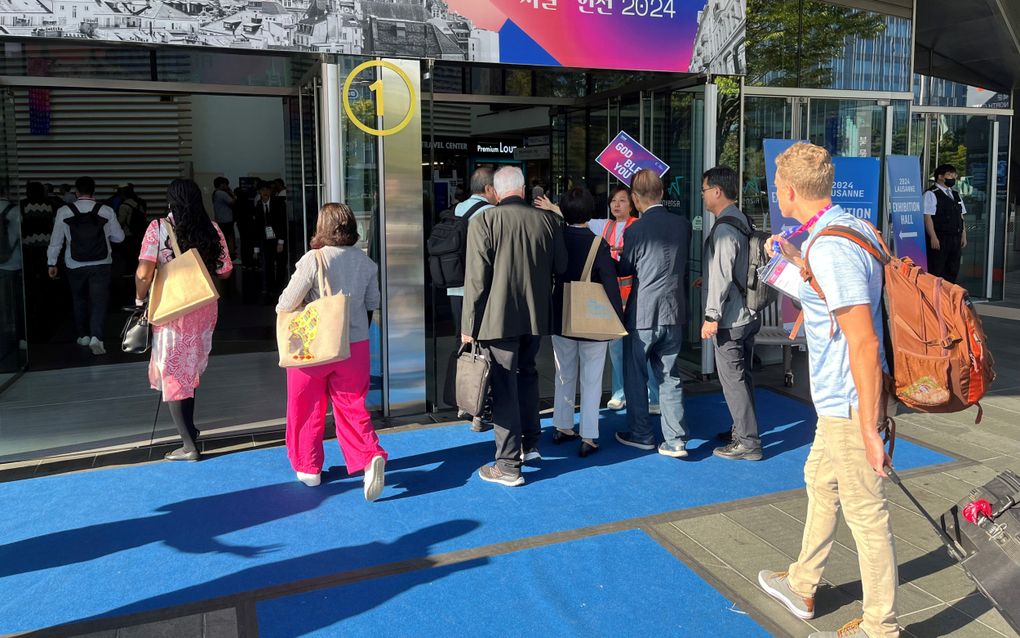 Een aantal deelnemers komt zaterdag aan bij het wereldevangelisatiecongres van de Lausannebeweging in Incheon, bij Seoel, in Zuid-Korea. Op de banner staat een foto van de Zwitserse stad Lausanne, waar de zendingsbeweging 50 jaar geleden werd opgericht. beeld RD