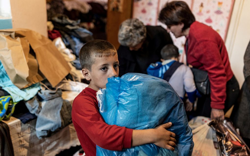 Een gevluchte jongen uit Nagorno-Karabach draagt zijn spullen een kleuterschool binnen die is omgevormd tot een tijdelijk onderkomen in de Armeense stad Masis. beeld AFP, Diego herrera Carcedo 