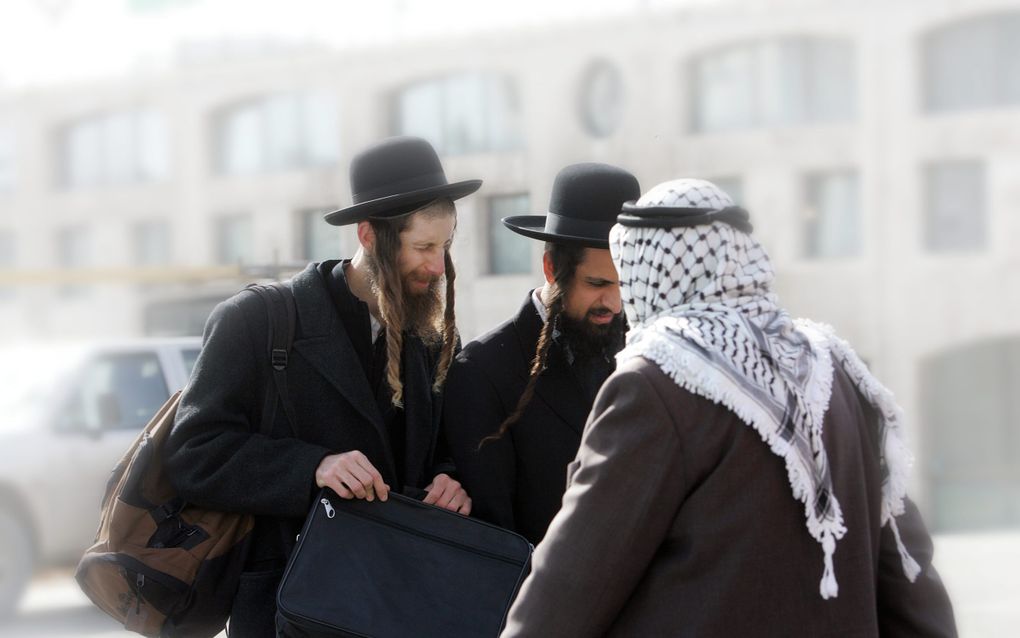 „Als Palestijnse christenen hebben we de dubbele last van discriminatie ervaren - ten eerste als Palestijnen en ten tweede als christenen.” Foto: Twee orthodoxe joden en een Arabier passeren elkaar op straat. beeld RD, Sjaak Verboom