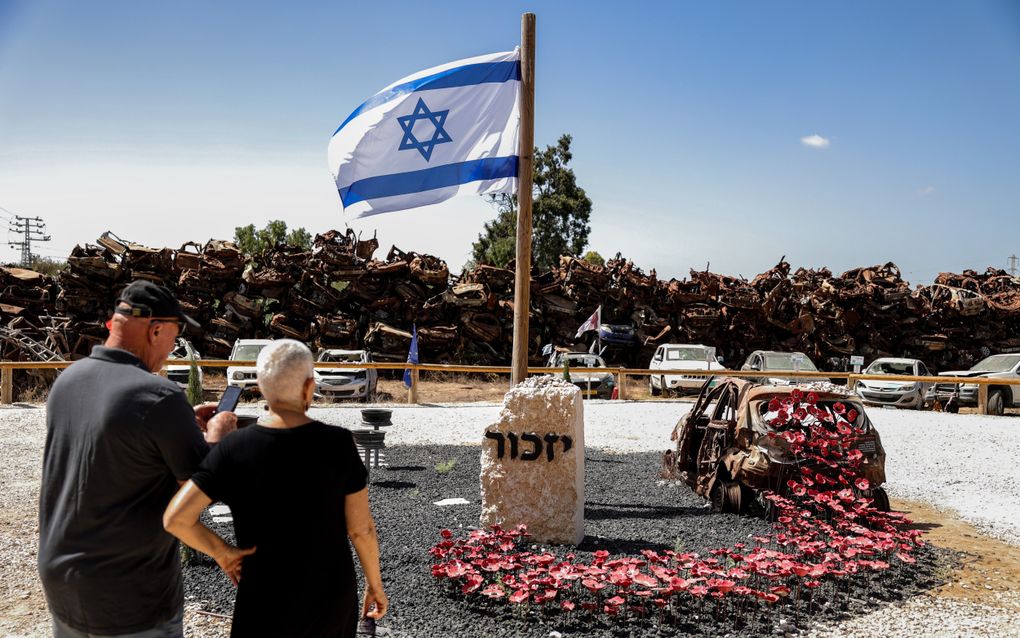 Bezoekers bekijken een gedenkteken van de aanval van Hamas op Israël, op 7 oktober 2023. Dit gedenkteken herinnert aan de meer dan 2000 auto’s die werden verwoest. Daarnaast zijn 1139 mensen om het leven gekomen en 251 gijzelaars gevangengenomen. beeld EPA, Abir Sultan