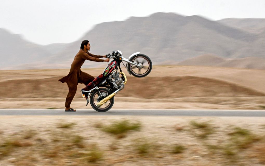 Een Afghaan laat zijn kunsten zien op een motor. beeld AFP, Atif ARYAN 