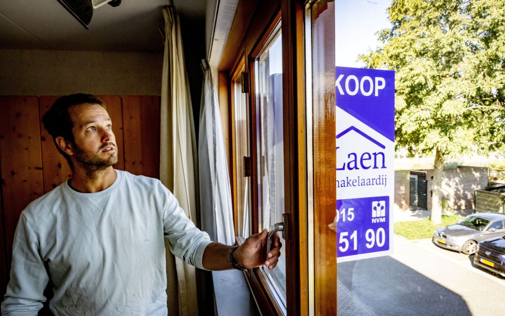 Een jongeman bekijkt een huis dat te koop staat. Om een huis te kunnen bemachtigen op de oververhitte woningmarkt, betalen starters tegenwoordig gemiddeld 42.000 euro uit eigen zak. beeld ANP, Robin van Utrecht