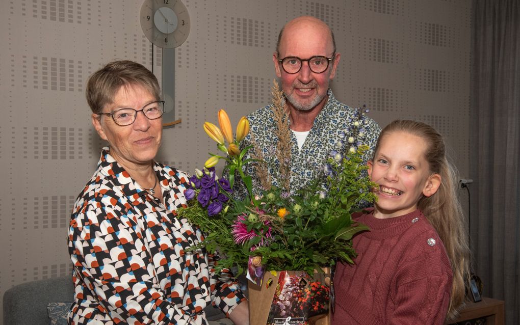 Lobke Buth (r.) geeft haar mantelzorgers, Adrie en Hannie Schot, een bos bloemen als dank voor hun liefdevolle zorg. beeld H.N. Copier