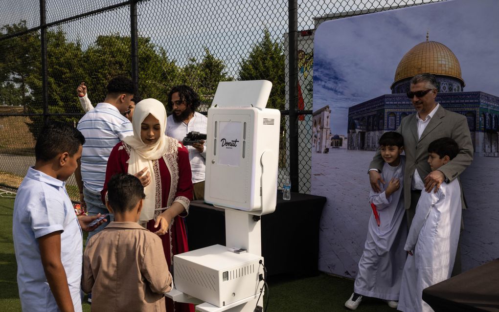 Moslims staan bij een fotohokje voorafgaand aan het ochtendgebed in de wijk Brooklyn in New York. beeld AFP, Yuki Iwamura 