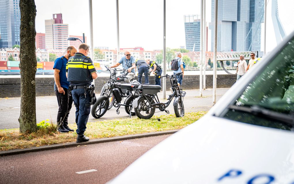 De politie spreekt met een omstander na een aanrijding tussen twee fatbikes in Rotterdam. Een chatbot zou de politie kunnen ondersteunen bij het doen van onderzoek. beeld ANP