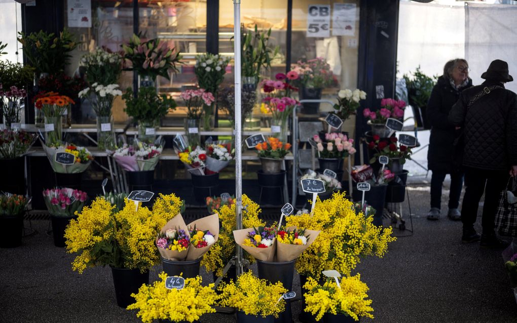 Een vrouw koopt bloemen op een markt in Toulouse. beeld AFP, Lionel Bonaventure  