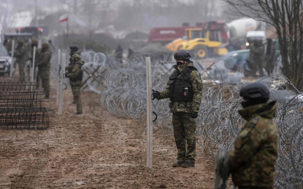 Poolse grenswachters houden de wacht tijdens de bouw van een grensmuur langs de Wit-Russische grens in Tolcze. beeld AFP, Wojtek Radwanski