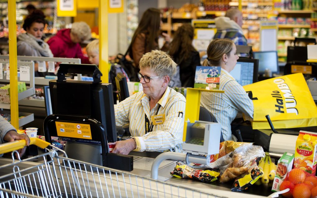 Een kassamedewerker rekent boodschappen af in een Jumbosupermarkt in Zwolle. Vanwege de toegenomen agressie vinden winkelpersoneel en zorgmedewerkers het lang niet altijd meer prettig om hun naam zichtbaar op hun kleding te dragen. beeld ANP, Olaf Kraak