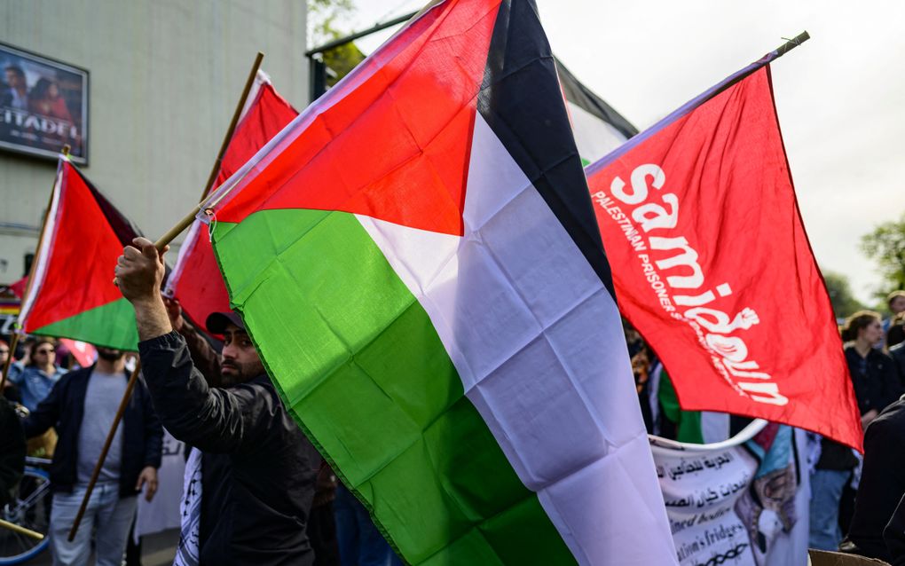 Leden van Samidoun zwaaien met een Palestijnse vlag tijdens een demonstratie in Berlijn in mei 2023. Beeld AFP, John MacDougall 