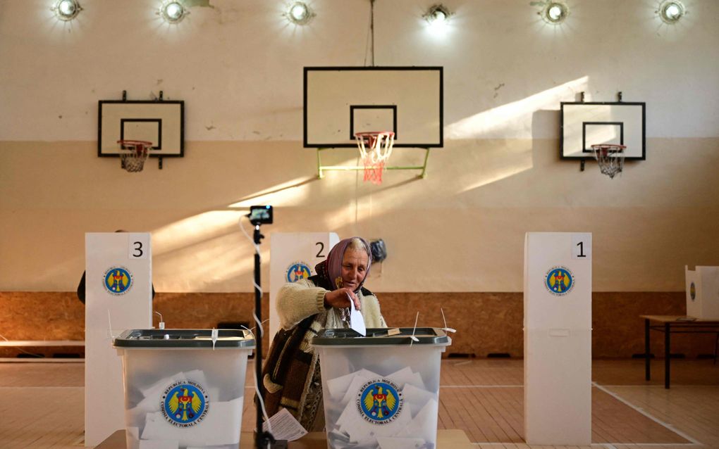 Een Moldavische vrouw brengt zondag in een gymzaal in Bulboaca haar stem uit voor het EU-referendum en de presidentsverkiezingen. beeld AFP, Daniel Mihailescu