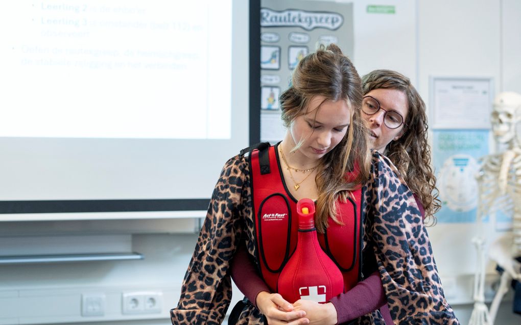 Docente Carla Lobbezoo (r.) laat haar klas zien hoe je iemand die dreigt te stikken op de juiste manier kunt helpen. beeld Niek Stam