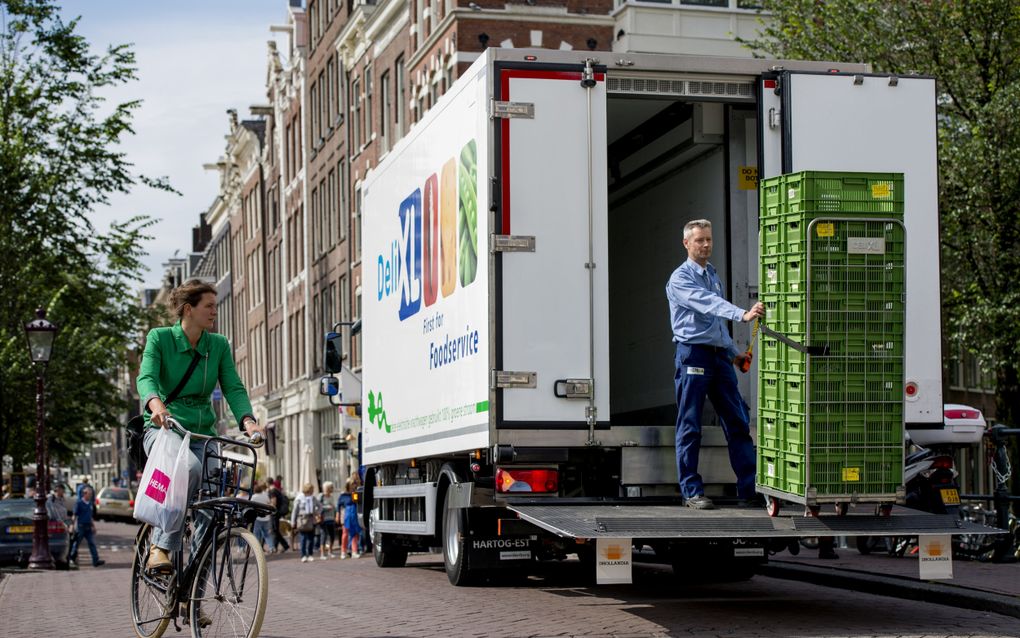 Een elektrische vrachtwagen in het centrum van Amsterdam. Veel meer steden willen het transport in de binnenstad emissievrij krijgen. beeld  ANP, Robin van Lonkhuijsen 